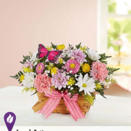 Basket of pink and white flowers with a butterfly decoration