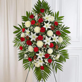 Standing floral spray with red roses, white lilies, and white pompons