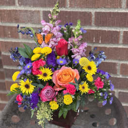 Colorful mixed bouquet with roses, daisies, and snapdragons in a vase