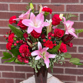 Pink lilies and red roses in a glass vase