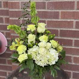 White and lime-green floral arrangement in a glass vase