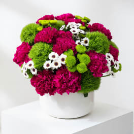 Magenta and green mixed bouquet in a white vase