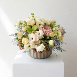 Pastel flower arrangement in a ribbed metal bowl