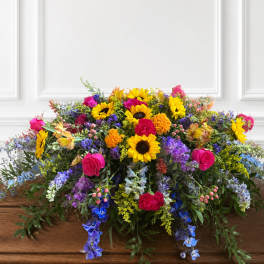 Colorful mixed flower arrangement on a wooden casket