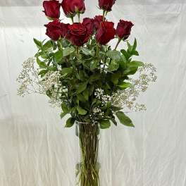 Tall vase arrangement of red roses with white baby's breath