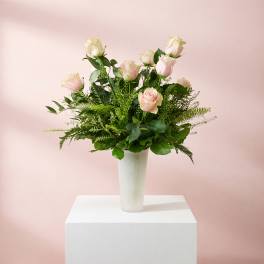 Pink roses arranged in a white vase