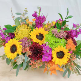 Bright mixed bouquet with sunflowers, magenta blooms, and orange accents