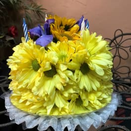 Yellow daisy bouquet with purple accents and striped candles