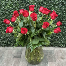 Red roses arranged in a clear glass vase