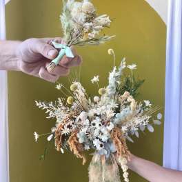 Dried flower bouquet with white and pale blue blooms tied with ribbon