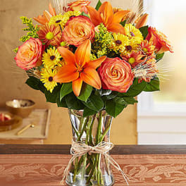 Orange and yellow mixed bouquet in a clear glass vase