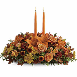 Autumn floral centerpiece with two orange taper candles