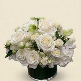 White rose and hydrangea arrangement in a dark glass vase