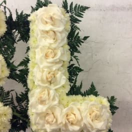 White rose floral arrangement with dark fern foliage