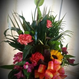 Mixed floral basket with carnations, sunflower, and tropical foliage