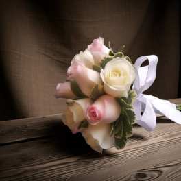Small bouquet of pale pink and white roses with a white ribbon