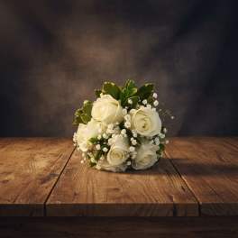 Small bouquet of white roses with baby's breath and greenery
