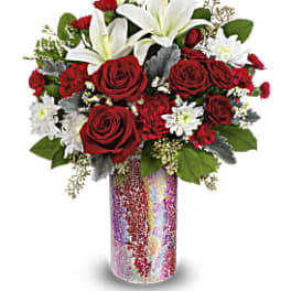 Red roses and white lilies arranged in a tall iridescent vase