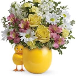 Yellow mug with mixed flowers and a small chick figurine
