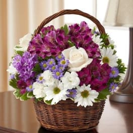 Basket of purple and white flowers with a white rose