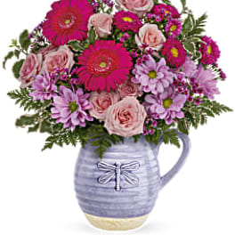 Pink and lavender mixed bouquet in a lavender ceramic pitcher vase