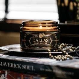 Amber glass candle jar with a black label on a tray