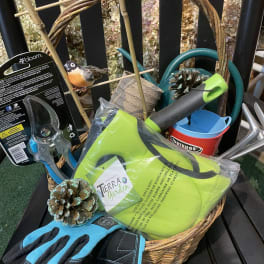 Basket of gardening tools and gloves with a small bird ornament
