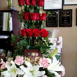Tall floral arrangement with red roses, white lilies, and pink carnations