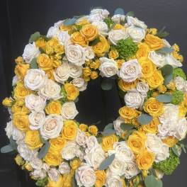 Large circular wreath of yellow and white roses with eucalyptus accents
