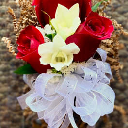 Red roses and white orchids with a sheer ribbon bow