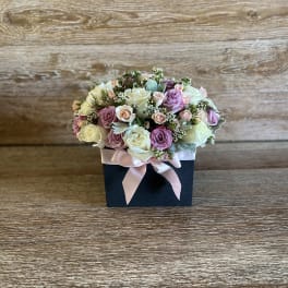 Pastel rose bouquet in a black box with a pink ribbon