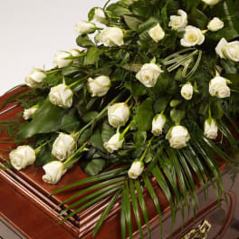 White roses arranged on a wooden casket