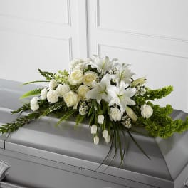 White floral casket spray with roses and lilies