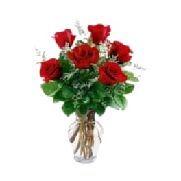 Red roses arranged in a clear glass vase
