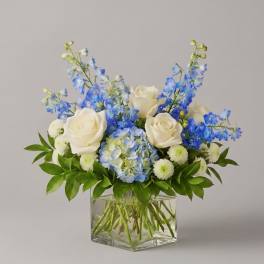 Blue and white flower arrangement in a clear glass vase
