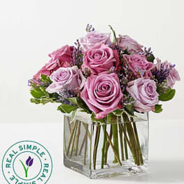 Pink and lavender roses in a clear square vase