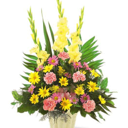 Mixed yellow, pink, and peach flowers in a gold vase