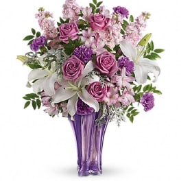 Purple and pink flower arrangement in a tall purple vase