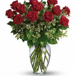 Red roses arranged in a clear glass vase