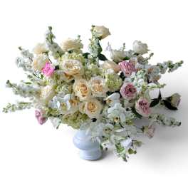 Cream and pink roses in a white vase with white orchids