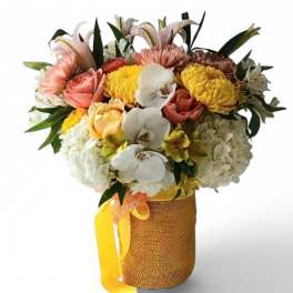 Mixed bouquet with orchids, roses, hydrangeas, and chrysanthemums in a burlap-wrapped vase