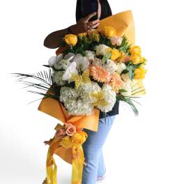 Large bouquet of yellow and white flowers with orange wrapping