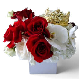 Red and white rose arrangement with a gold crown in a white vase