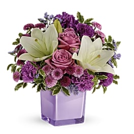 Purple bouquet with white lilies and pink roses in a lavender vase