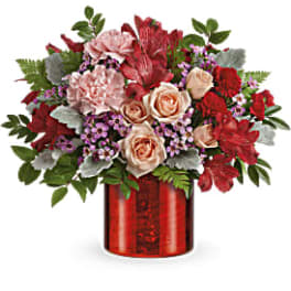 Red and blush floral arrangement in a red vase
