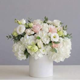 White and blush bouquet in a white cylindrical vase