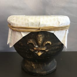 Decorative dark pedestal bowl with a white patterned cover and tied ribbon