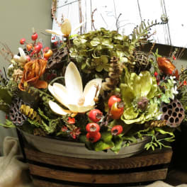 Mixed floral arrangement with white and orange blooms in a wooden container