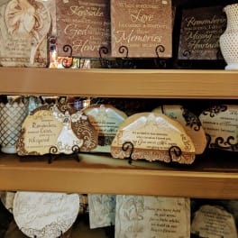 Shelves of decorative memorial plaques with angel and sympathy messages