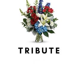 Tribute bouquet with red, white, and blue flowers in a glass vase